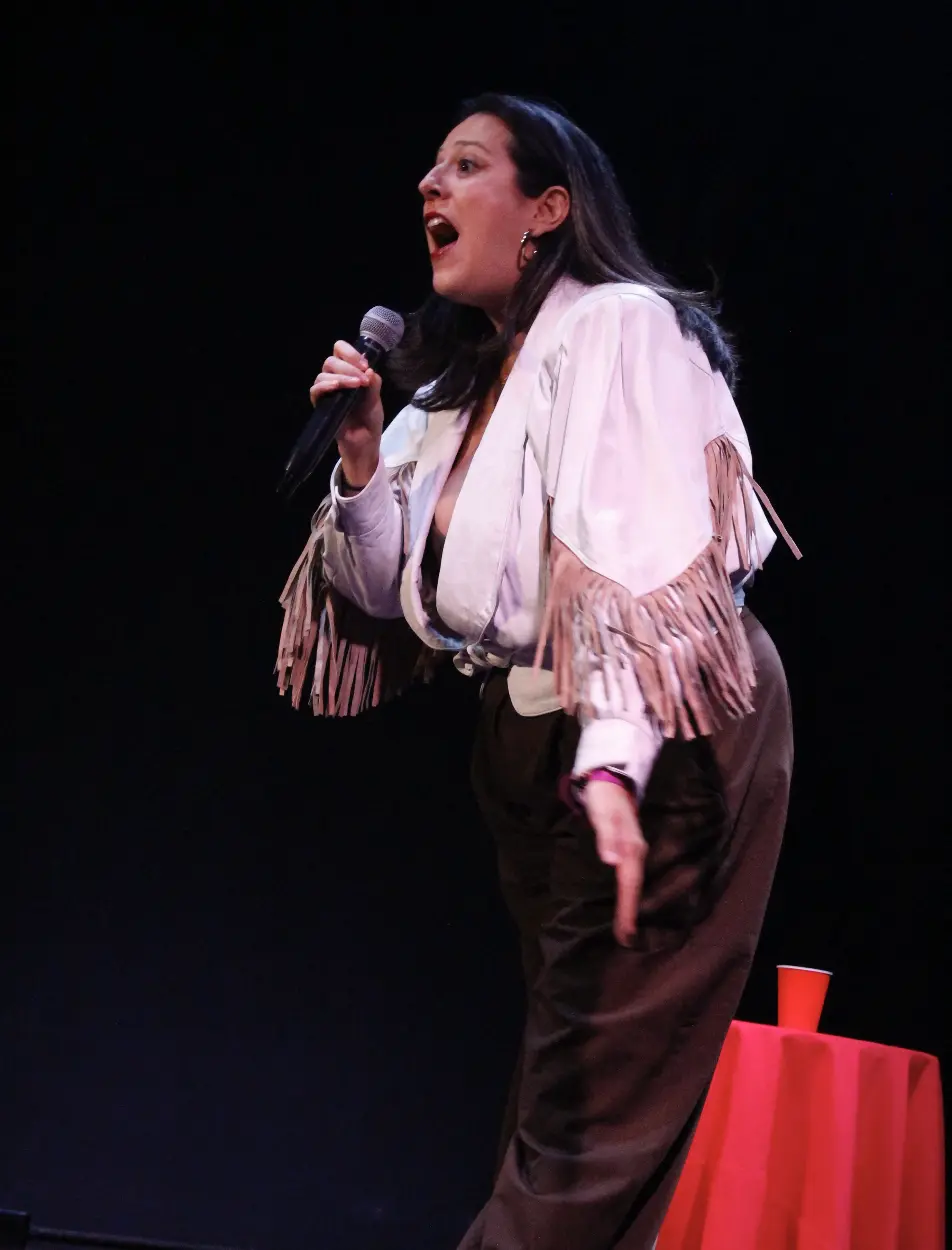 María A Secas presentándose en vivo con un micrófono